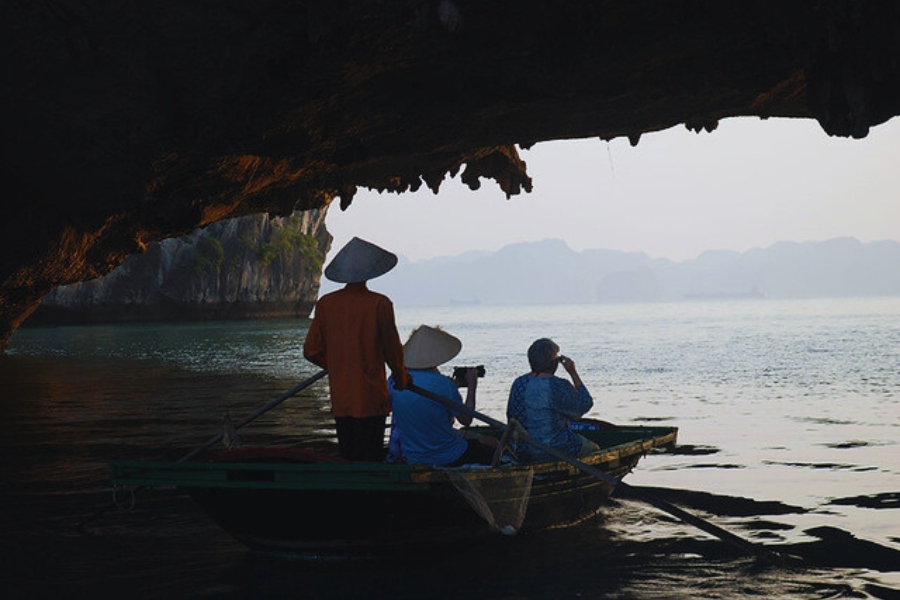 Traditional bamboo boat exploring cave on Halong Bay Day Cruises with Auasia Travel